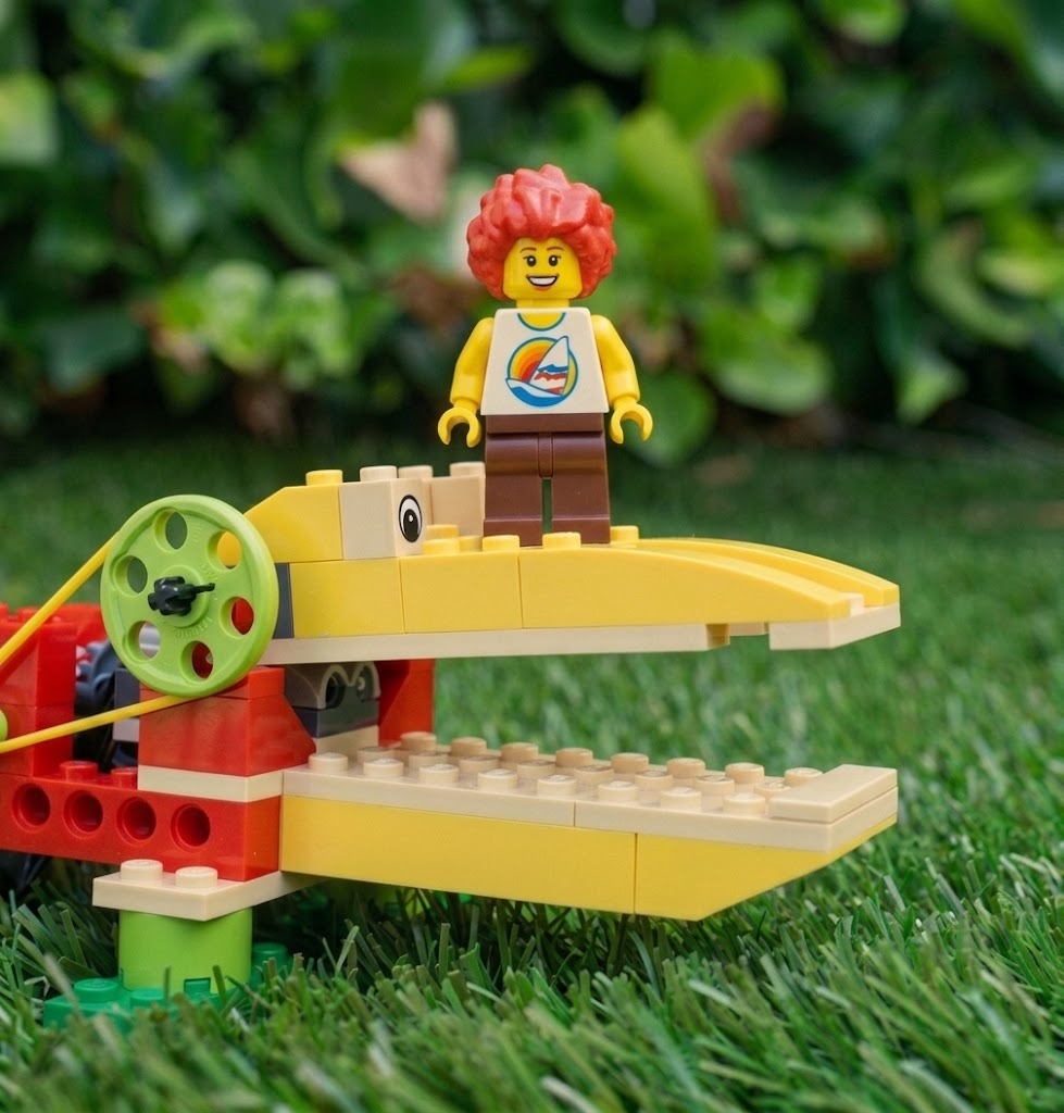 Caimán robótico LEGO WeDo con la boca cerrada y minifigura contenta