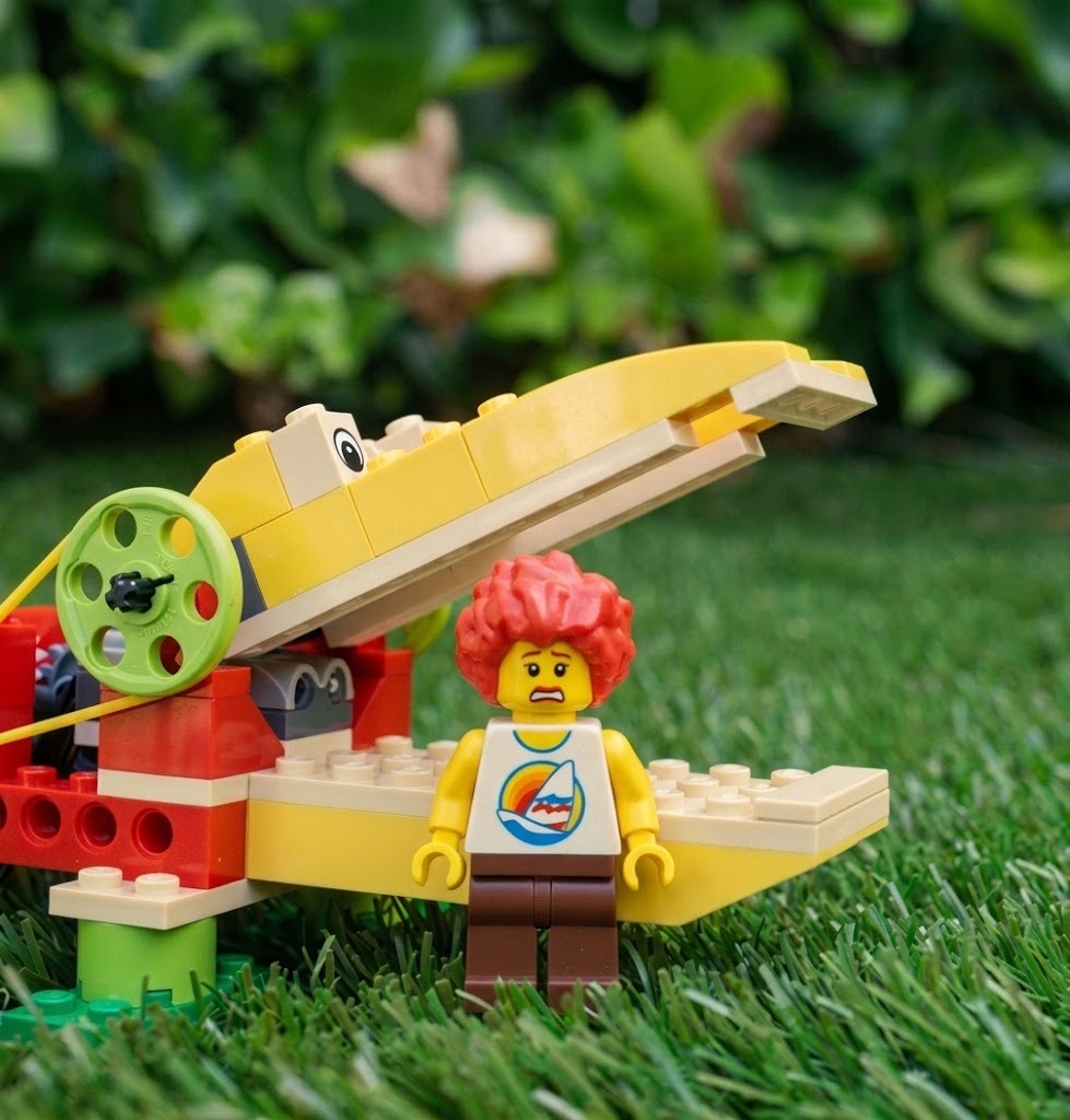 Caimán robótico LEGO WeDo con la boca abierta y minifigura asustada