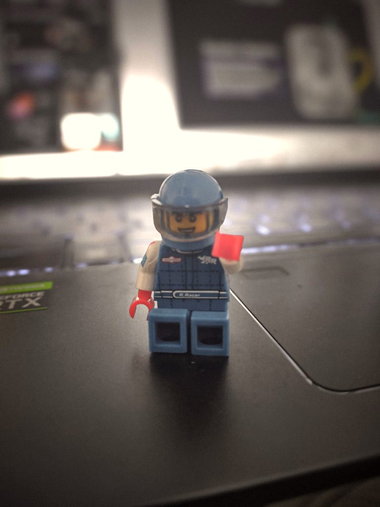 Minifigura LEGO con casco de pie sobre el teclado de un portátil