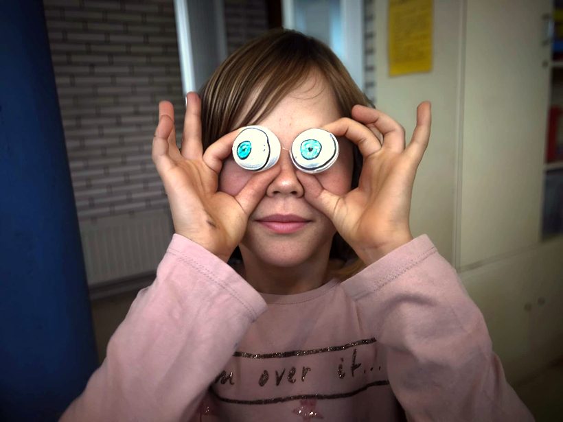 Alumna con dos piezas redondas de LEGO a modo de ojos