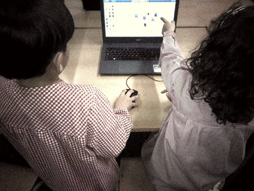 Dos alumnos programando en un portátil
