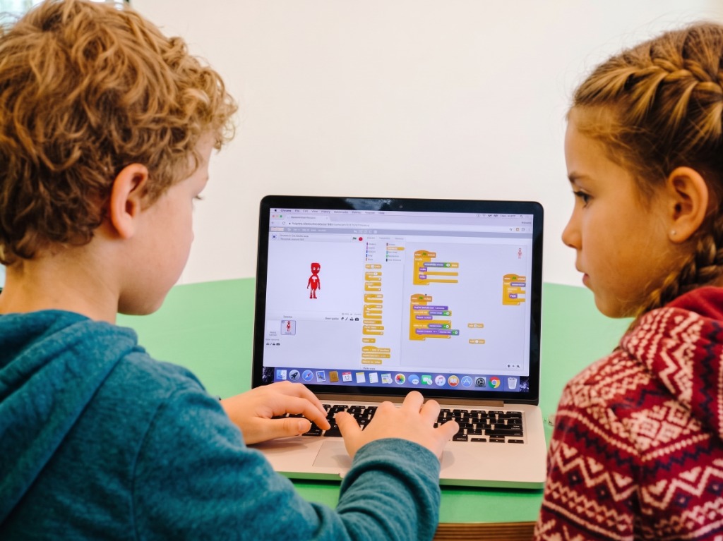 Alumnos programando un proyecto en Scratch en el portátil